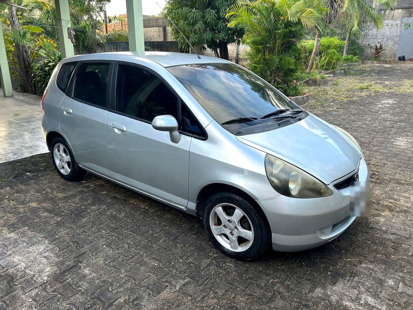 Honda Fit prata visto de frente e de lado